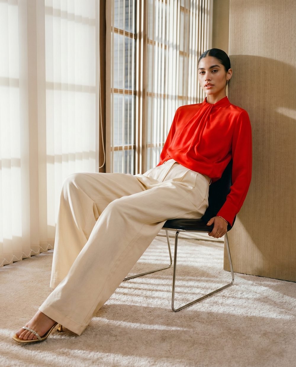 Editorial fashion visual — red blouse in sunlit interior