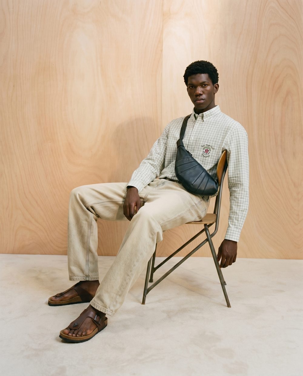 Editorial fashion visual — checked shirt and sling bag